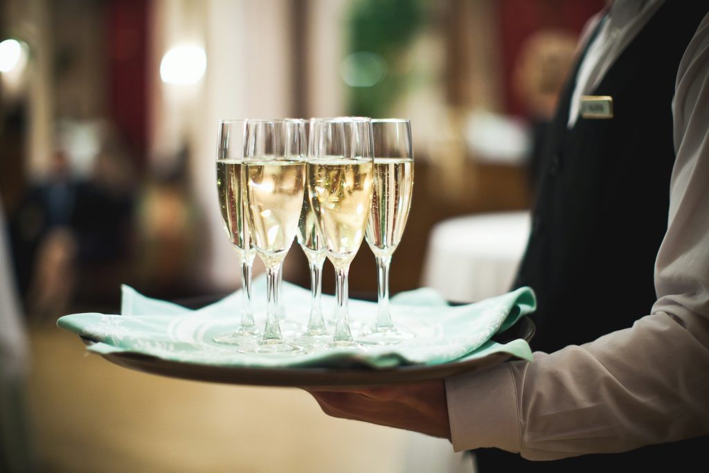 Waiter serving champagne on a tray on luxury cruise - Viking Travel