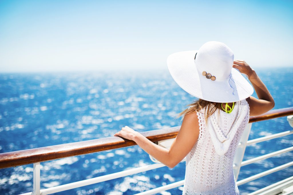 oman with hat on a cruise ship looking at the view - Viking Travel