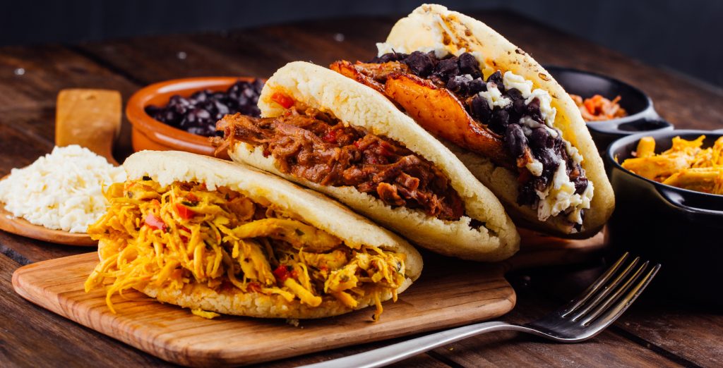 Arepas with several ingredients to fill like chicken, meat, black beans, fried plantain, Colombia - Viking Travel