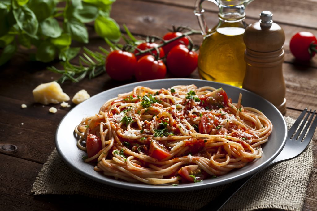 Pasta with tomato sauce shot on rustic wood table - Viking Travel