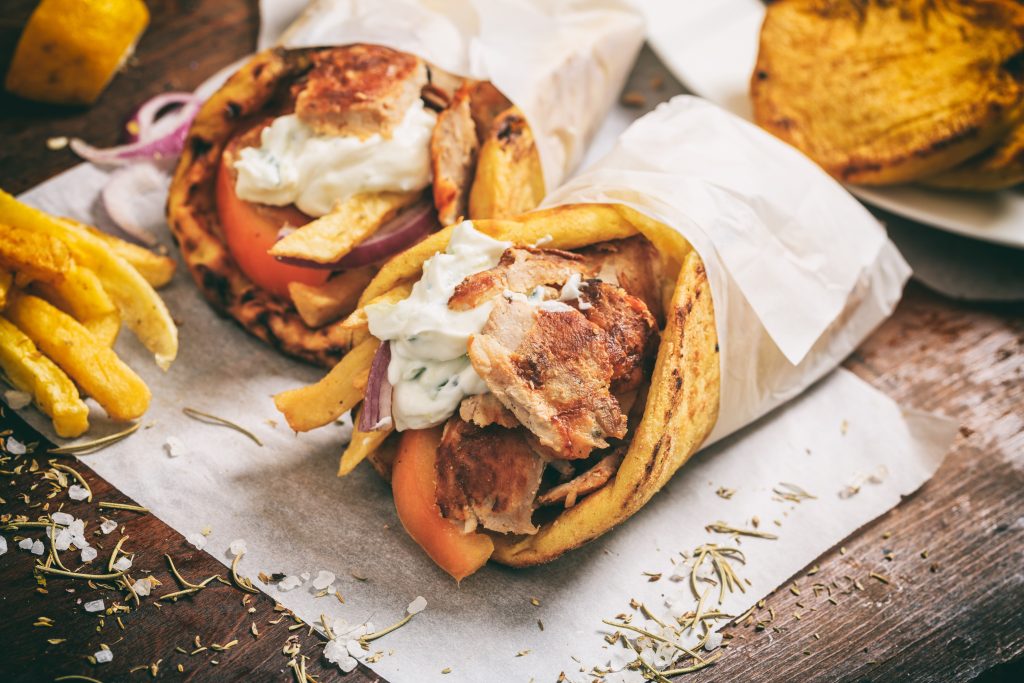 Greek gyros wraped in a pita bread on a wooden background - Viking Travel